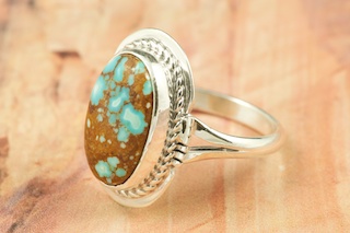 Genuine Number 8 Turquoise set in Sterling Silver Ring. The Number 8 mine is located in Eureka County Nevada. Since 1976 there has been no Number 8 Turquoise mined. There is however, an existing stock pile that Mr. Dowell Ward, the last owner of the Number 8 mine, had stocked away for later sorting. The Turquoise is a collector's item--because once the reserve is gone there will be no more material released onto the market. The Gold Mining Company owns the claim to the Number 8 mine and it has been swallowed up by the gold mining operations. This is some of the last Number 8 Turquoise to be had and will be a great addition to your collection. Created by Navajo Artist Margaret Platero. Signed by the artist.